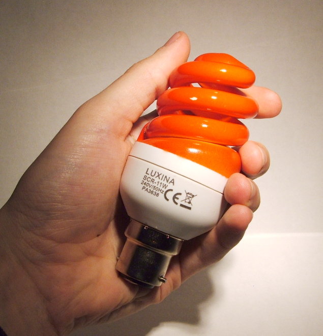 Luxina SCR-11W Orange Coloured Compact Fluorescent Lamp - Shown in hand for relative sense of scale